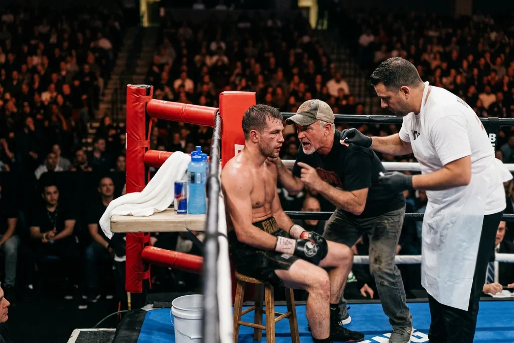 Boxeadores en sus esquinas entre asaltos con equipos de esquina